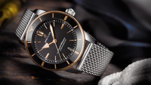 En Breitling-klokke med sort skive og brune detaljer ligger