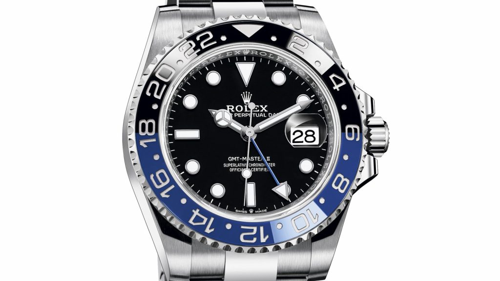 Nærbilde av en Rolex-klokke med sort skive og blå og sort bezel.